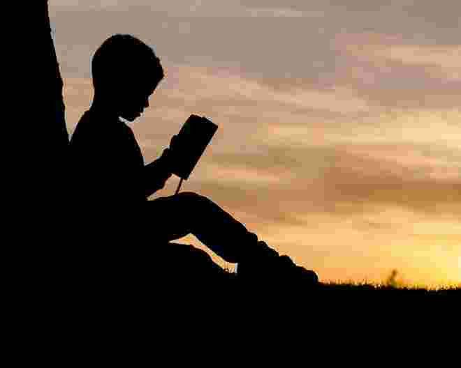 silhouette of a child reading